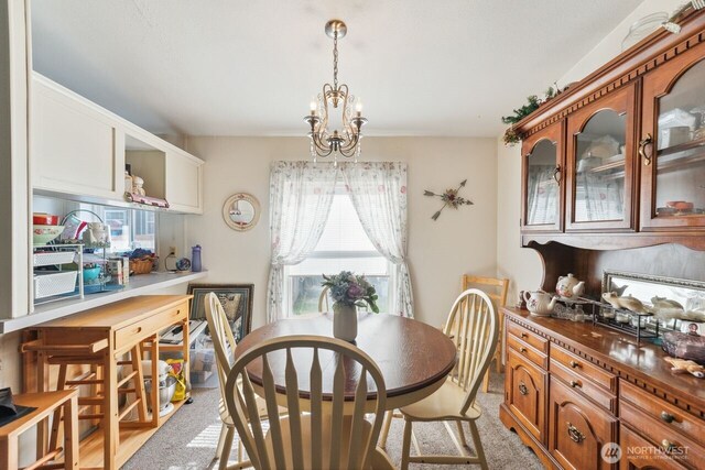 dining area with a notable chandelier and light carpet