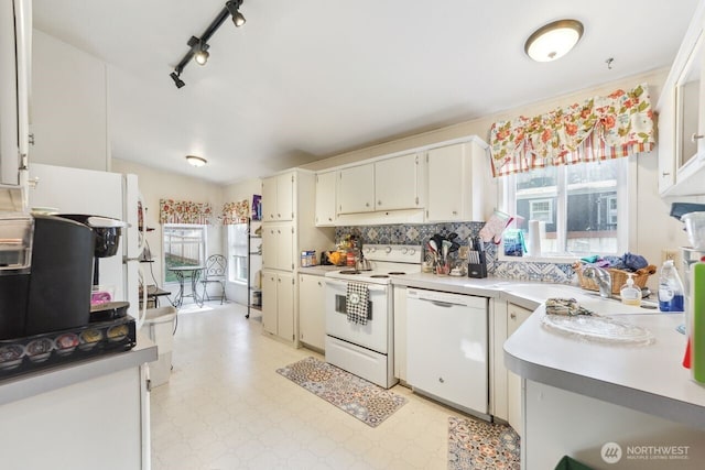 kitchen with tasteful backsplash, light floors, light countertops, white appliances, and a sink