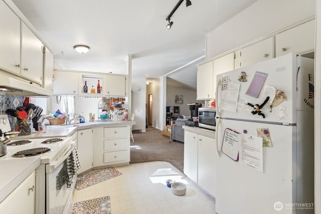 kitchen with a sink, white appliances, rail lighting, and light countertops