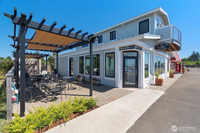 rear view of property with a patio area and a pergola