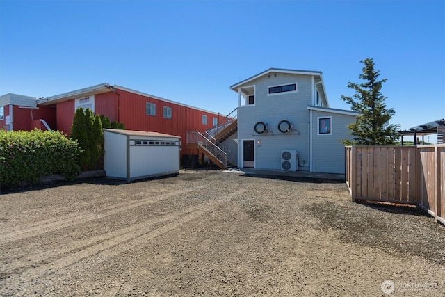 view of front of property with an outdoor structure, stairway, and fence