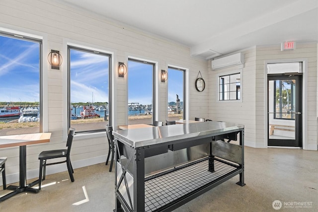 dining area featuring a wall mounted air conditioner and baseboards