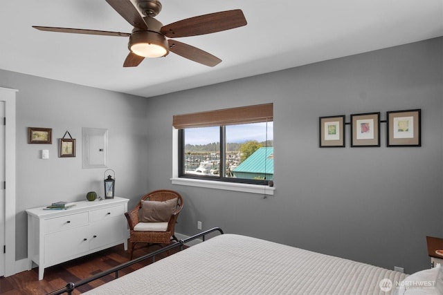 bedroom featuring electric panel, wood finished floors, baseboards, and ceiling fan