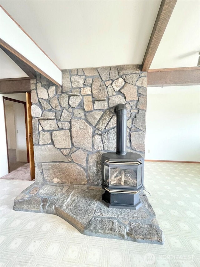 details with beamed ceiling, baseboards, and a wood stove