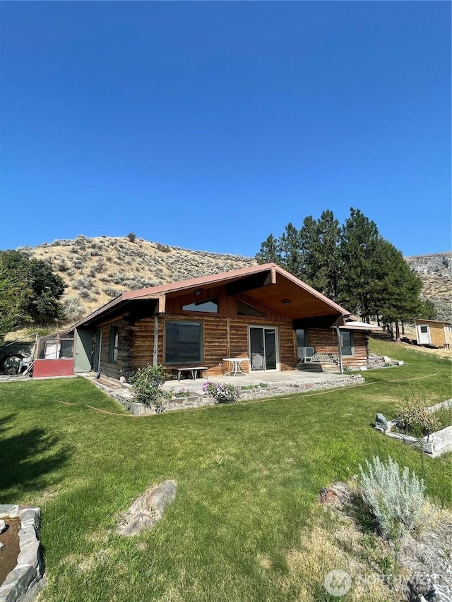 rear view of property featuring a patio and a lawn