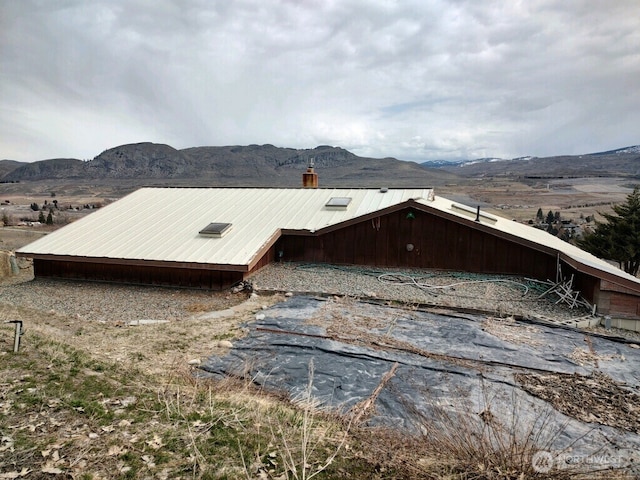 view of home's exterior featuring a mountain view and a chimney