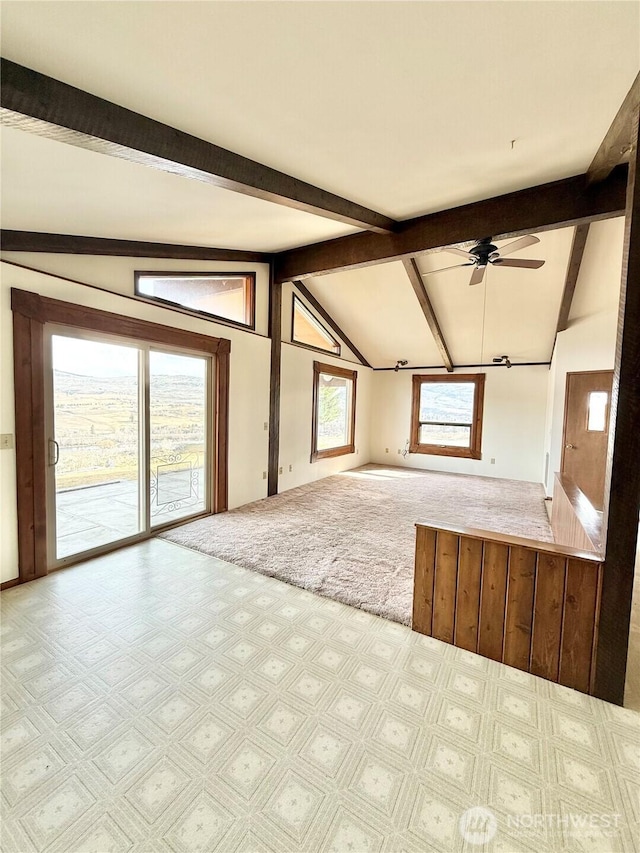 unfurnished living room featuring vaulted ceiling with beams, a ceiling fan, and carpet floors
