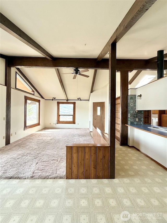 kitchen featuring open floor plan, vaulted ceiling with beams, ceiling fan, and carpet floors