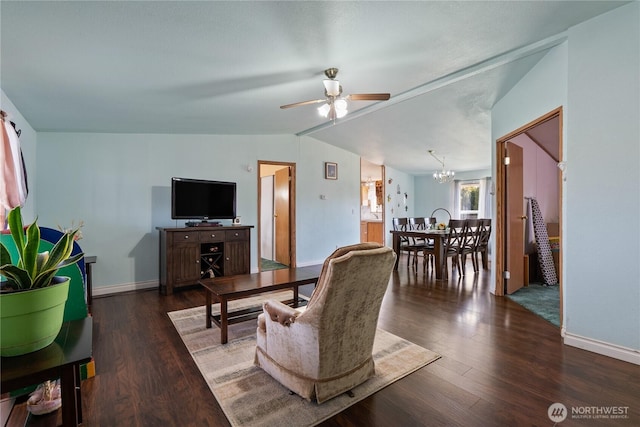 living room featuring ceiling fan with notable chandelier, baseboards, lofted ceiling, and wood finished floors