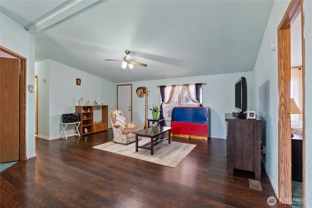 living area with baseboards, wood finished floors, ceiling fan, and vaulted ceiling with beams