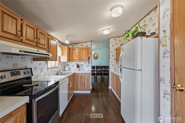 kitchen with visible vents, under cabinet range hood, wallpapered walls, white appliances, and light countertops