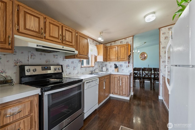 kitchen featuring under cabinet range hood, a sink, white appliances, light countertops, and lofted ceiling