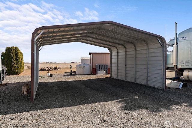 view of parking / parking lot with a detached carport and gravel driveway