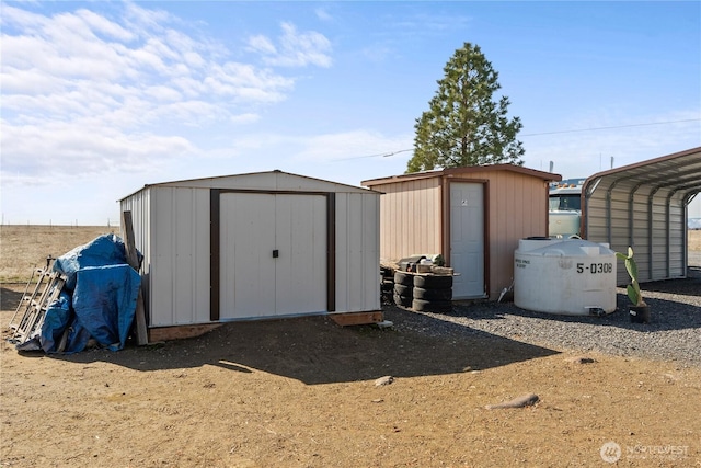 view of shed featuring a carport and dirt driveway