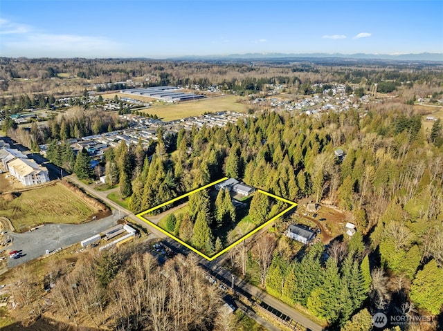 drone / aerial view featuring a wooded view