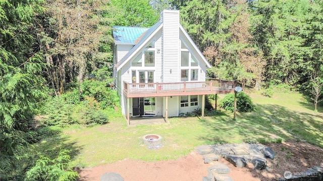 19002 20th St NW, Lakebay, WA 98349 - rear view of house featuring a wooden deck, a lawn, a fire pit, and a chimney