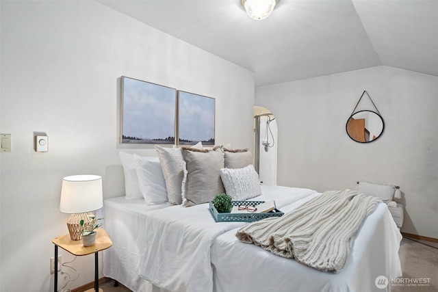 bedroom with baseboards and vaulted ceiling