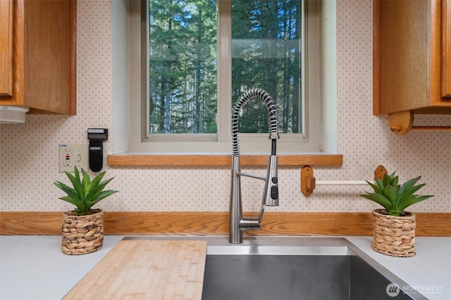 details featuring light countertops, backsplash, and a sink