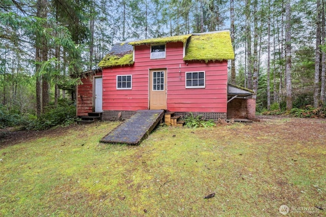 rear view of house with a yard and entry steps