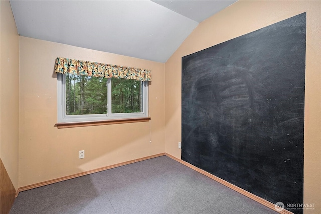 spare room with lofted ceiling, baseboards, and carpet floors