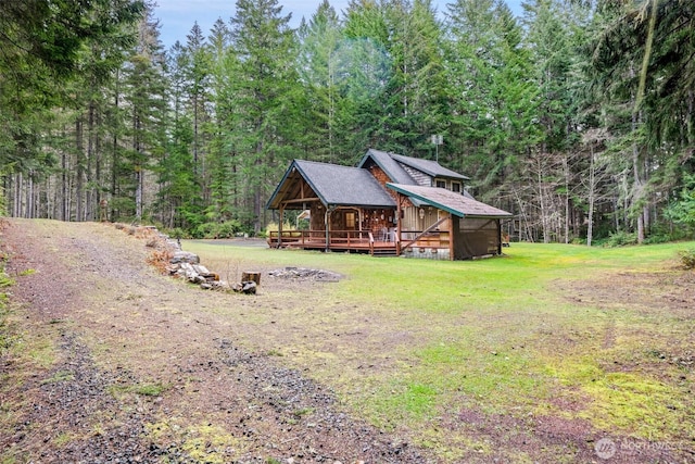 view of front of house with a front lawn, a wooded view, and crawl space