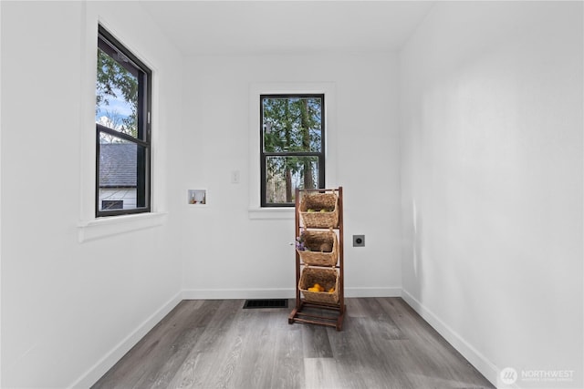 unfurnished room with visible vents, baseboards, and wood finished floors