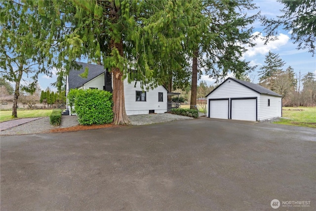 exterior space with an outbuilding and a detached garage