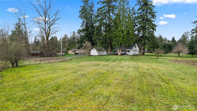 view of yard featuring an outbuilding and fence