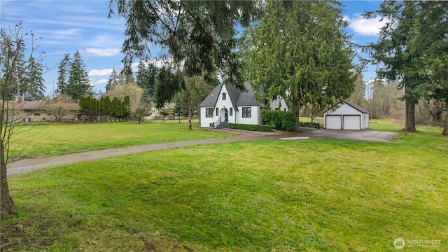 view of front of property featuring a detached garage, an outdoor structure, a front yard, and fence