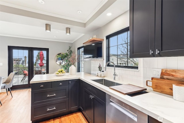 kitchen featuring dishwasher, a peninsula, a wealth of natural light, and a sink