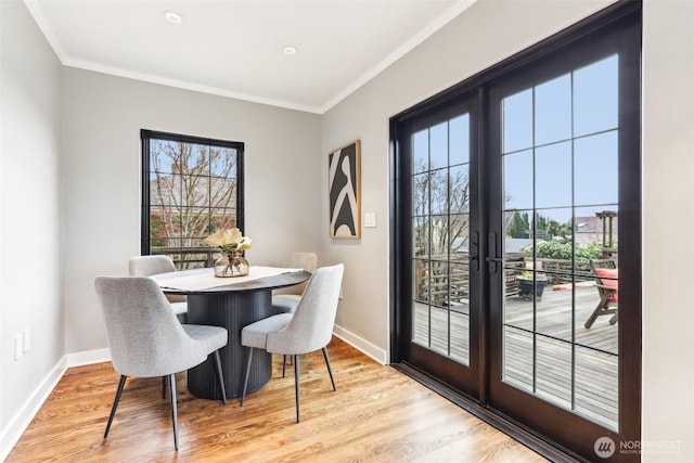 dining area with light wood-style floors, baseboards, french doors, and ornamental molding