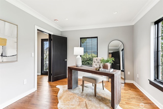 office area featuring light wood-style flooring, crown molding, and baseboards