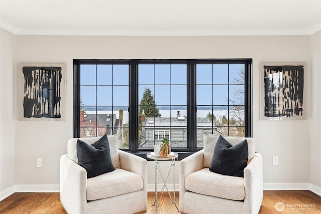 sitting room with ornamental molding, baseboards, and wood finished floors