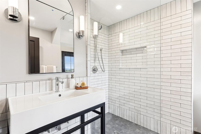 bathroom with decorative backsplash, tiled shower, and vanity