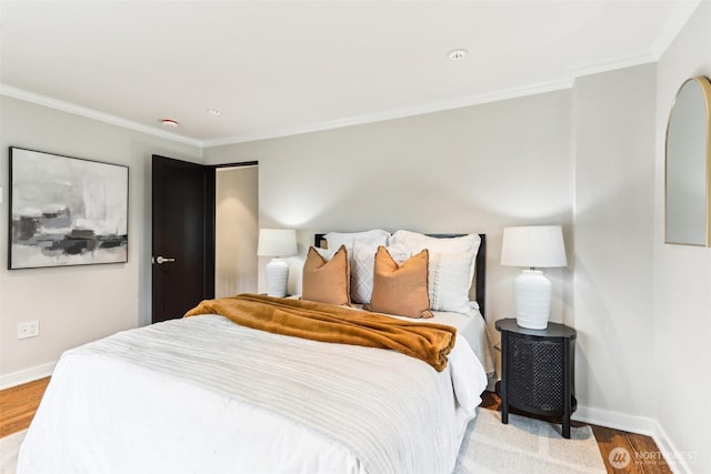 bedroom featuring crown molding, baseboards, and light wood finished floors