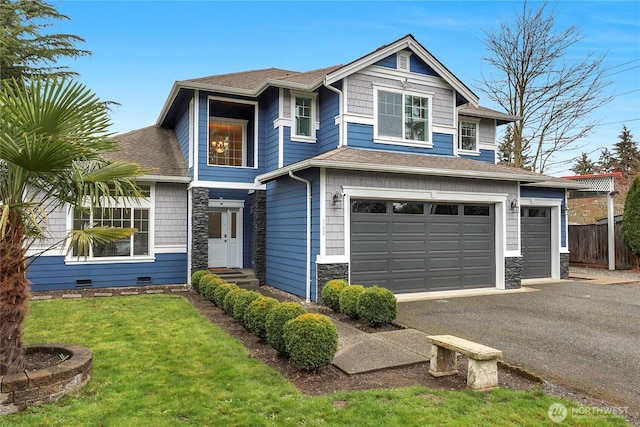 view of front of house featuring a shingled roof, a front lawn, fence, stone siding, and driveway