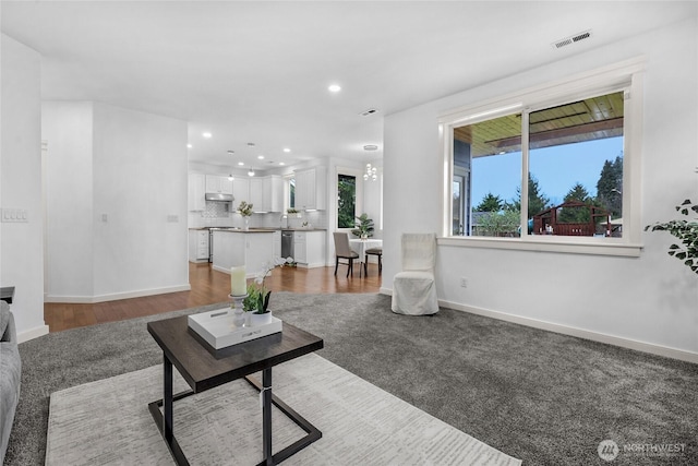 living area with wood finished floors, recessed lighting, baseboards, and visible vents