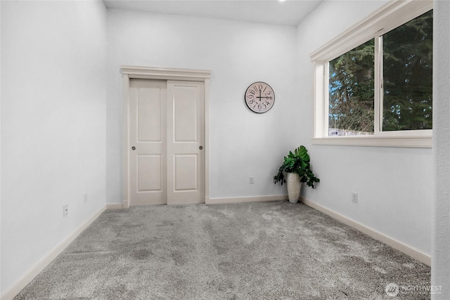 empty room with baseboards and carpet floors