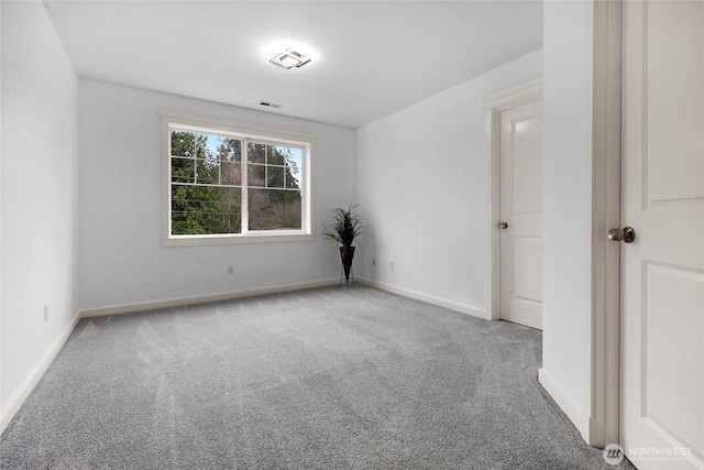 unfurnished room with visible vents, baseboards, and carpet flooring