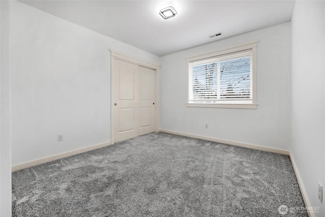 unfurnished bedroom with carpet, visible vents, and baseboards