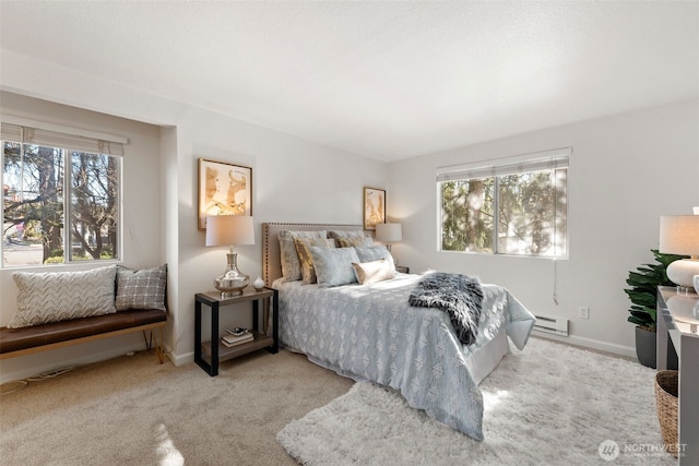 carpeted bedroom featuring a baseboard heating unit and baseboards