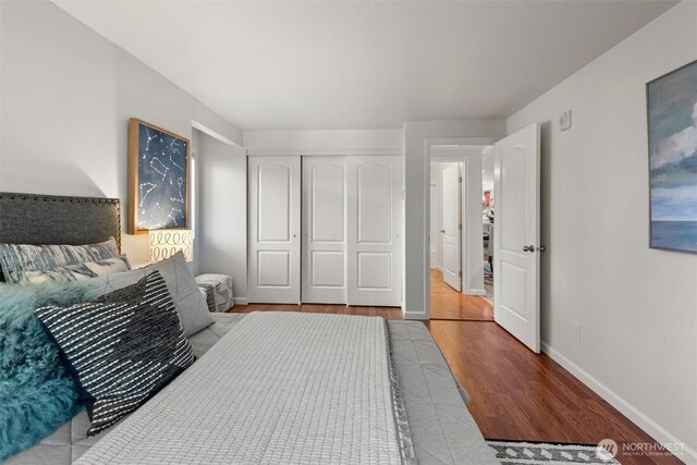 bedroom featuring a closet, baseboards, and wood finished floors