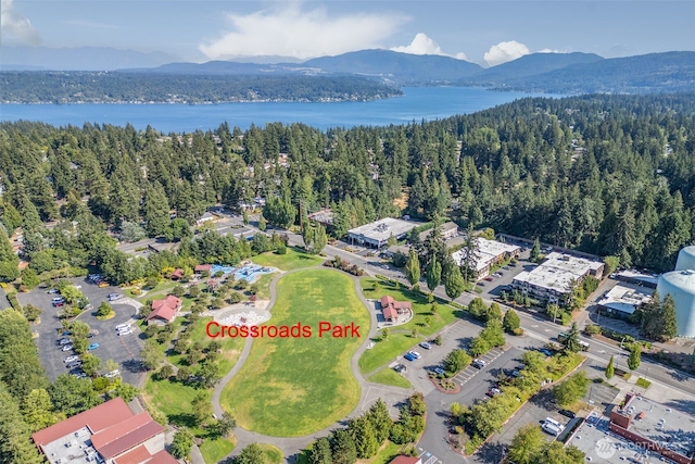 drone / aerial view with a forest view and a water and mountain view