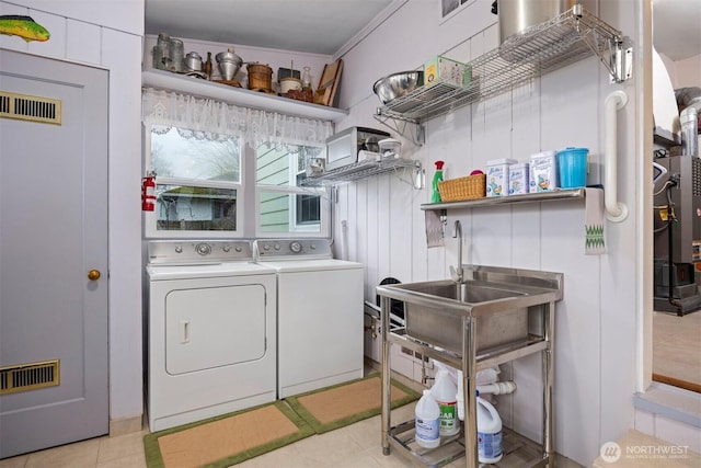 washroom featuring washing machine and clothes dryer, laundry area, and visible vents