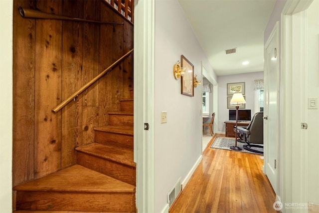 stairs featuring visible vents, baseboards, and wood finished floors