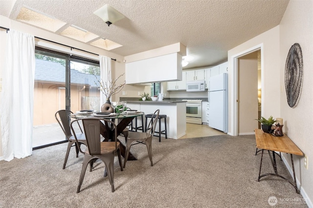 dining area featuring light colored carpet and a textured ceiling