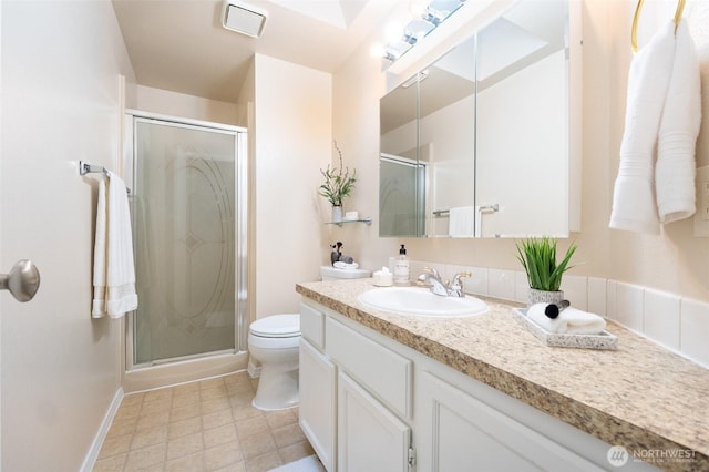 bathroom featuring baseboards, toilet, a stall shower, and vanity