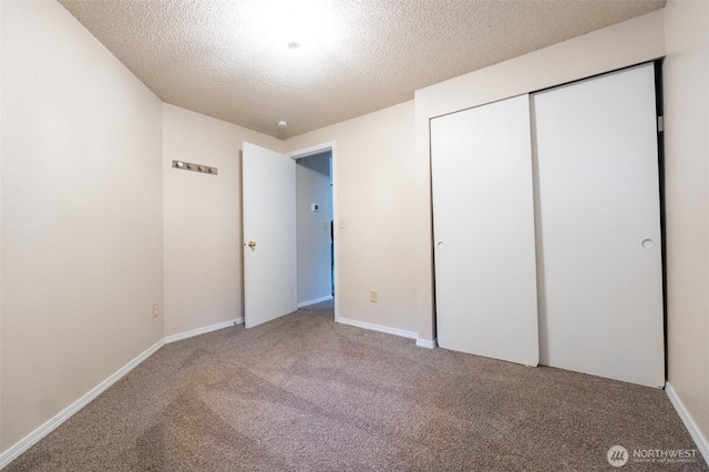 unfurnished bedroom with a closet, carpet, and a textured ceiling