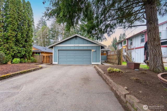 view of front of home featuring an outbuilding, fence, and driveway