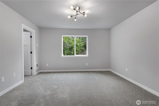 carpeted spare room featuring visible vents and baseboards